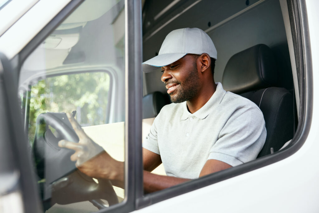 Delivery Man Reading Addresses Sitting In Delivery Van