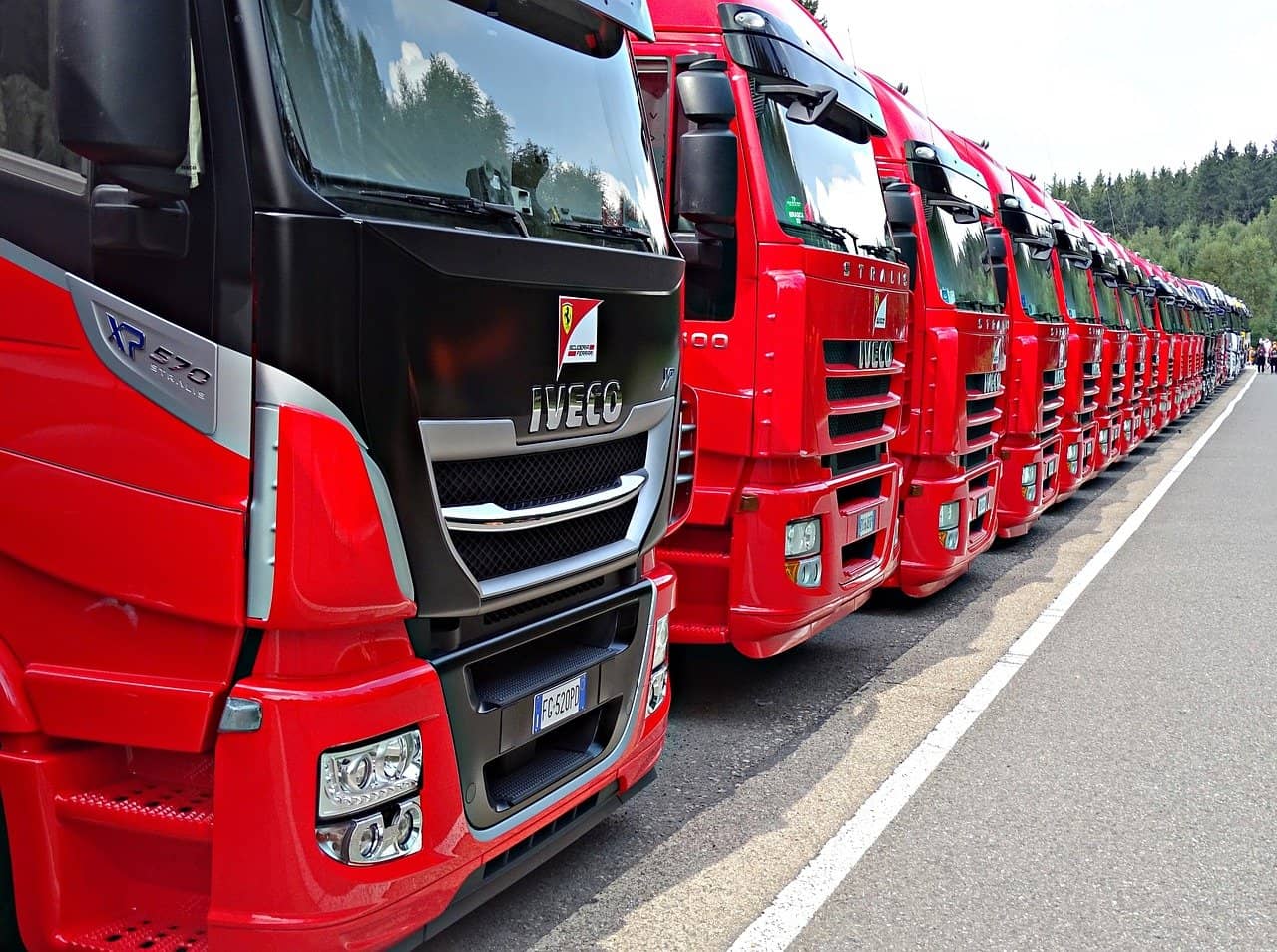 A number of red trucks parked side by side
