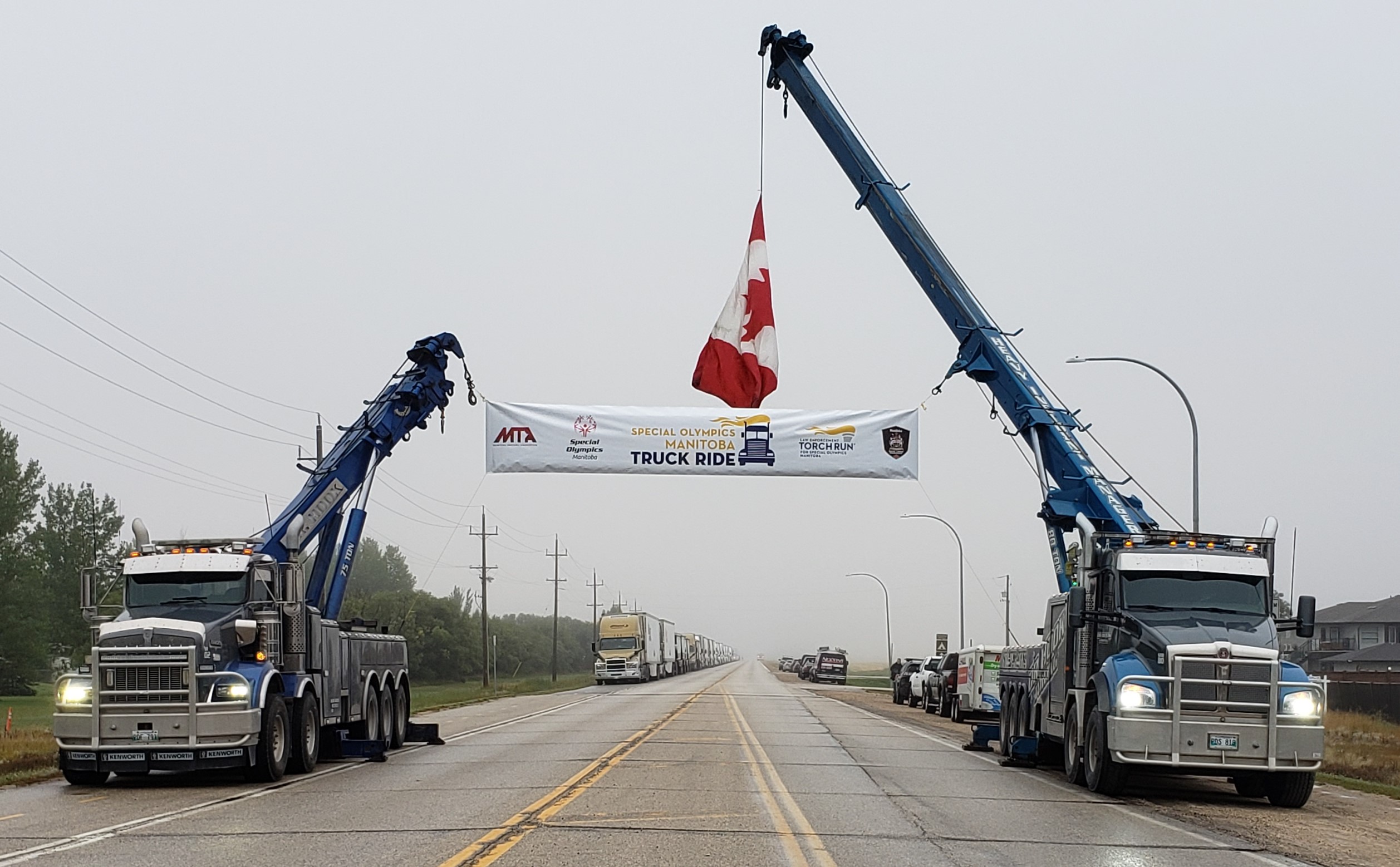 A banner and a  Canada flag attached to two blue trucks