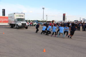 A group of people pulling a truck with a rope