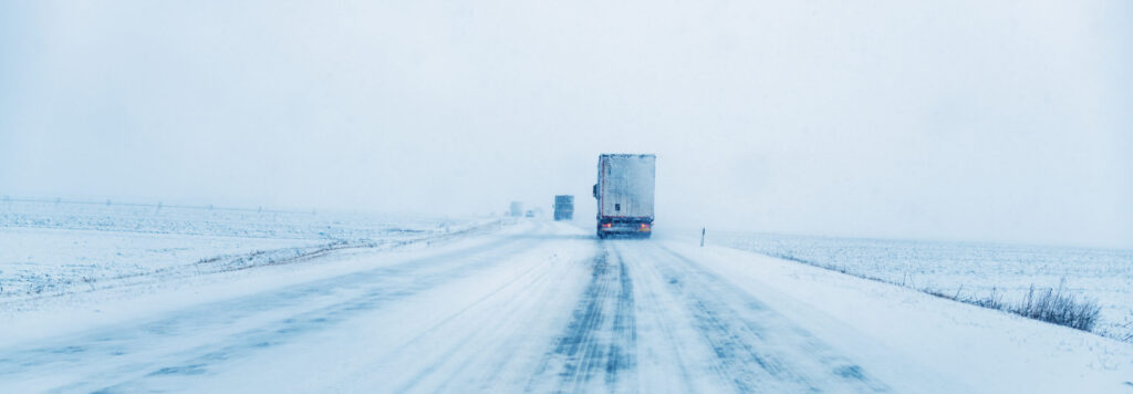 Freight transportation truck on the road in snow storm blizzard