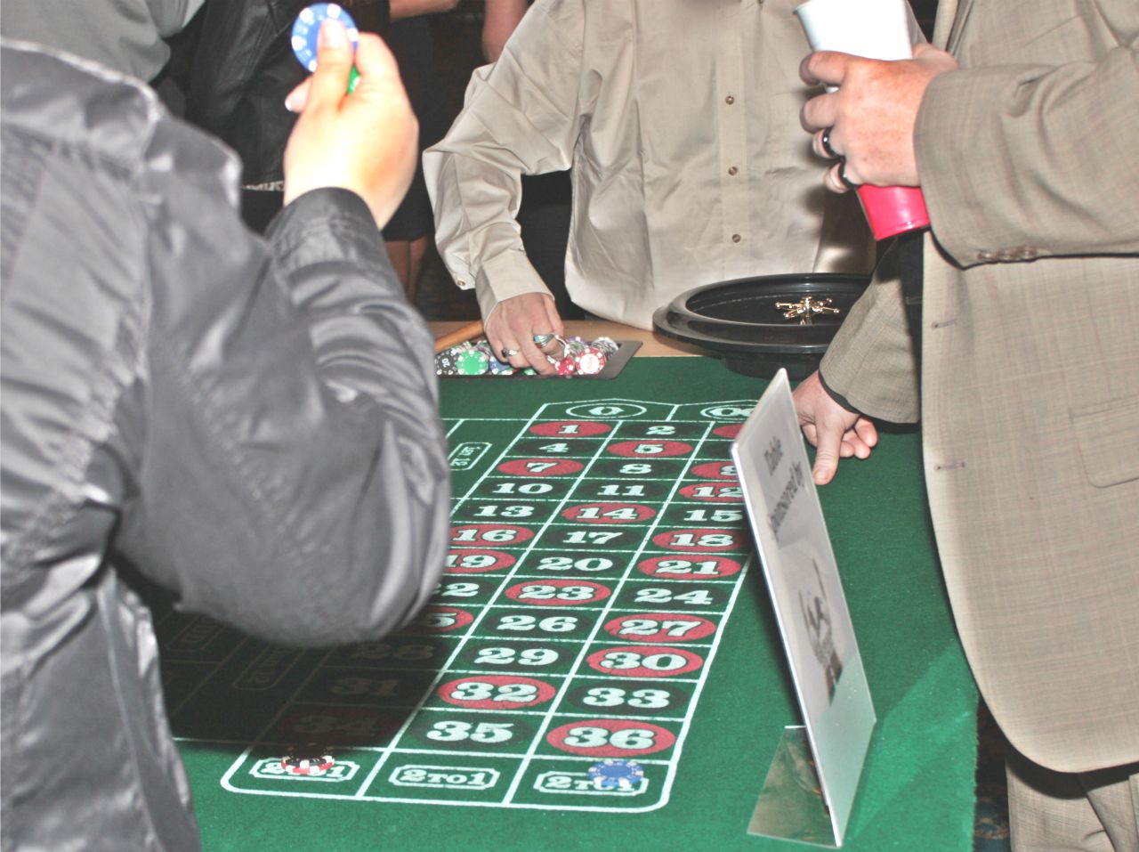 An image of people at a casino table placing chips on the table
