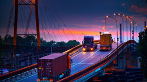 Commerical trucks on a bridge at twilight.