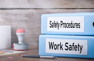 A picture of binders labelled Safety Procedures and Work Safety o a desk.