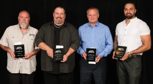 A picture of four people holding plaques for winning second place