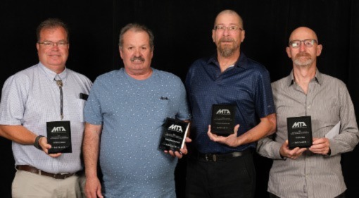 A picture of four people holding plaques for winning third place.