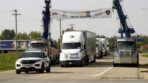 A picture of a commercial truck driving under a banner for Special Olympics.