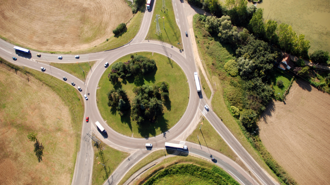 An aerial view of a roundabout style traffic intersection.