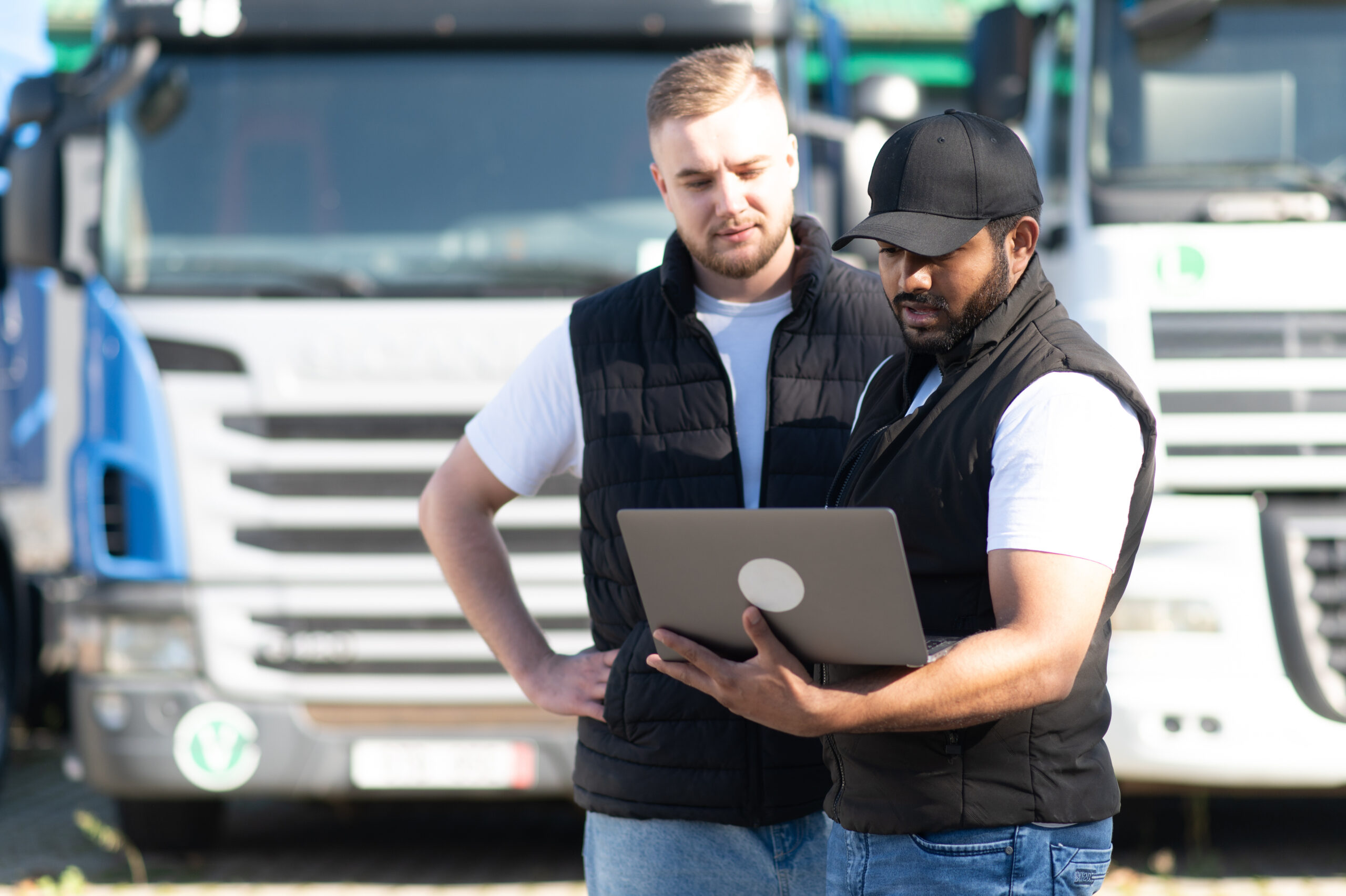Truck driver checking logistics data on laptop
